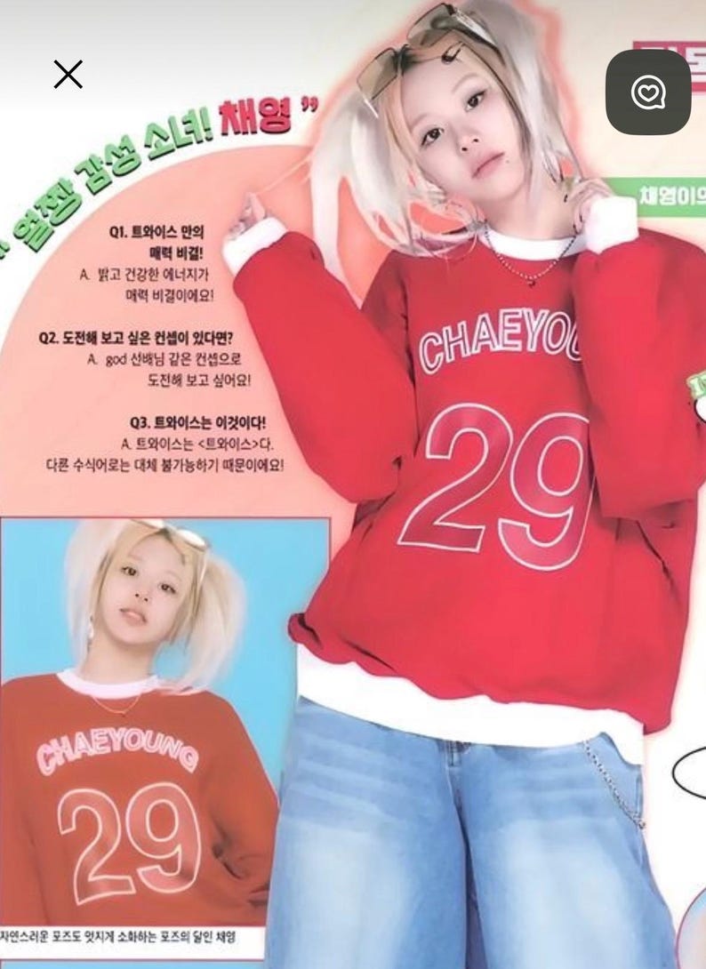 May include: A red sweatshirt with the name "CHAEYOUNG" and the number "29" in white. The person in the image is wearing light blue jeans and sunglasses. The image also contains Korean text.
