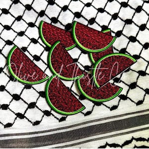 May include: A collection of watermelon slice patches with a red patterned design and green trim. The patches are arranged on a black and white checkered fabric with the text "Olive and Thistle Co."