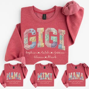 May include: Red sweatshirt with the word "GIGI" in patchwork letters. Below the name are the names Sophia, Laleh, Jessica, Alani, and Mark. Additional sweatshirts with "MAMA", "MIMI", and "NANA" are also shown.