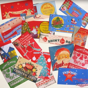 Op de afbeelding: Een assortiment vintage verpakkingen voor kerstverlichting en kerstversiering in de kleuren rood, blauw en groen. De verpakkingen bevatten de woorden "Christmas Lights", "Shiny Brite", "Glolite", "Noma", "Timio", "Sterling", "Kas-Kel", "Usalite", "Indoor Tree Set" en "General Electric".
