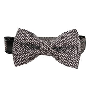 May include: A dark brown bow tie featuring a white grid pattern. The bow tie is attached to a matching dark brown collar strap with a black plastic side-release buckle, creating a cohesive accessory with a repeating geometric design.