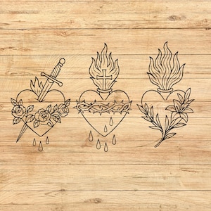 Puede incluir: Tres ilustraciones en blanco y negro de corazones sobre un fondo de madera. Un coraz&oacute;n con una espada y rosas, otro con una corona de espinas y una cruz, y el tercero con lirios.