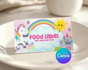 May include: A rectangular printable food label tent featuring a white unicorn with a rainbow mane, a colorful rainbow, a yellow sun, a gray castle, and flowers. The text reads "food label" and "ADD YOUR OWN TEXT" with a blue "EDIT IN Canva" circle.
