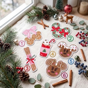 May include: Six Christmas-themed stickers featuring a pink bow with bells, a green wreath with red bows, a red drink with whipped cream, a gingerbread cookie, cinnamon sticks tied with a red ribbon, and a gingerbread character with a bow.