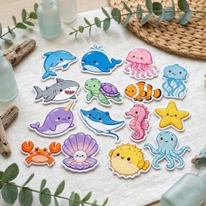 May include: A collection of fifteen embroidered patches featuring cartoon sea creatures including a blue dolphin, a whale, a pink jellyfish, a shark, a green turtle, a clownfish, a narwhal, a stingray, a seahorse, a starfish, a crab, a shell, a pufferfish, and an octopus.