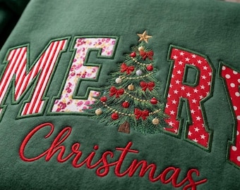 May include: A dark green sweatshirt featuring the embroidered text MERRY with a Christmas tree replacing the letter E. The letters M, R, and Y have red and white patterns, while the E is a floral print. The word Christmas is embroidered below.