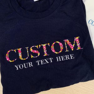 Besticktes T-Shirt mit Blumenbuchstaben, benutzerdefiniertes College-gesticktes Sweatshirt, College-Hochschul-Shirt, High-School-Shirt