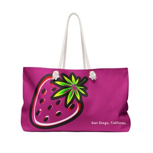 May include: A pink tote bag with a white rope handle and a graphic of a stylized strawberry with green leaves. The text "San Diego, California" is printed on the bag.