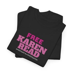 Könnte beinhalten: Schwarzes T-Shirt mit dem Text "FREE KAREN READ" in rosa und weißen Buchstaben. Der Text "INVESTIGATE the INVESTIGATION" ist in weiß unter dem Haupttext gedruckt.