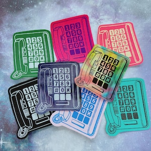 May include: A collection of colorful, retro-style telephone patches. Each patch features a rectangular design with a telephone handset and number keypad. The patches come in various colors, including green, pink, black, blue, and a tie-dye pattern.