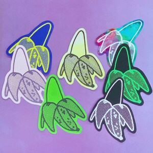 Könnte beinhalten: Sechs bunte Aufkleber mit einer stilisierten Illustration einer Blume mit drei Blütenblättern. Die Aufkleber sind in verschiedenen Farben, darunter Grün, Gelb, Lila, Schwarz und Blau.