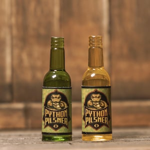 May include: Two small glass bottles of beer with green and yellow labels. The labels feature a snake design and the text "Python Pilsner".