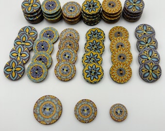 May include: A collection of decorative wooden buttons in various sizes and designs. The buttons feature floral and geometric patterns in shades of yellow, blue, and brown. Some buttons are stacked, while others are arranged in rows, showcasing their intricate details.