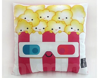 May include: A white pillow with a red and white striped popcorn bucket design. The bucket has 3D glasses on it and is filled with popcorn with smiling faces. The pillow has the text "mymimi" on the bottom right corner.