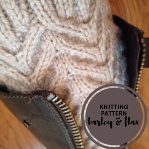 May include: Close-up of a knitted boot cuff in a beige color with a cable knit pattern. The cuff is partially tucked into a brown leather boot with a zipper. The text "Knitting Pattern barley & flax" is visible in a circle on the boot.