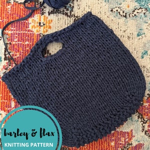May include: A dark blue knitted tote bag with a large handle opening. The bag is made with a chunky yarn and has a textured, rope-like stitch. The text "barley & flax knitting pattern" is on a teal circle.