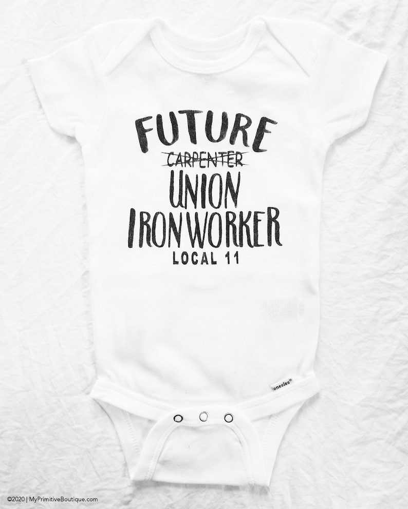 May include: White baby onesie with black text that reads "Future Carpenter Union Iron Worker Local 11".