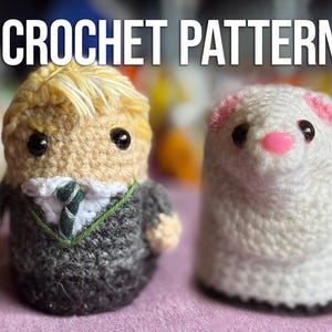 May include: Crochet pattern featuring two amigurumi figures. One is a doll with a blonde hairstyle, wearing a dark suit and tie. The other is a white ferret with pink ears and nose. The text "CROCHET PATTERN" is at the top.
