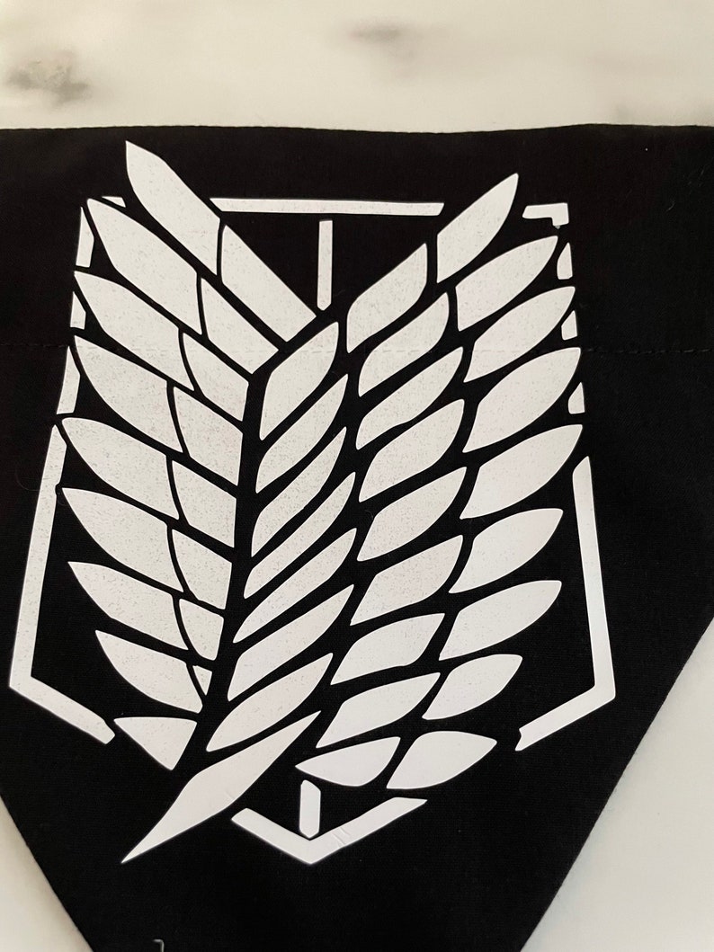 May include: Black fabric patch with a white winged emblem. The emblem is a stylized wing with a central vertical line and a rectangular frame.