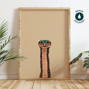 May include: A framed art print depicting a stylized snake illustration. The snake has a green and blue head, a red and black body, and is set against a beige background. The frame is made of light-coloured wood. The image also includes the text "BONUS COLOURS!"