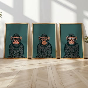May include: Three framed prints of black and white illustrations of gorillas with orange eyes and eyebrows. The gorillas are wearing glasses. The frames are teal green and the background is a light wood floor.