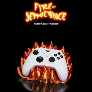 Peut inclure: Manette de jeu vidéo blanche reposant sur un support en forme de flamme orange et jaune. Le texte "FIRE-SEMBLANCE CONTROLLER HOLDER" est au-dessus de la manette.