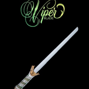 Może przedstawiać: Srebrny miecz z rękojeścią w kształcie węża. Rękojeść jest zielona i złota z fakturowanym wzorem. Miecz jest oznaczony jako "Viper Blade".