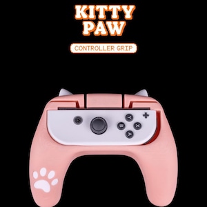 Może przedstawiać: Różowy uchwyt kontrolera Kitty Paw do Nintendo Switch. Uchwyt ma odcisk łapy po bokach i kocie uszy na górze.