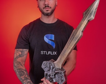 May include: A person wearing a black t-shirt with the logo "STLFLIX" printed on the front, holding a large, ornate, silver-colored sword with a black handle.