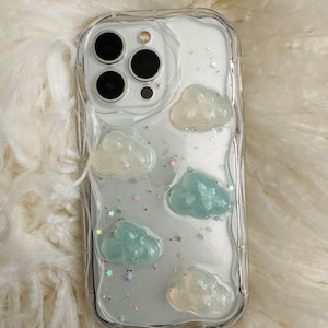 May include: Clear phone case with a white and blue cloud design and glitter accents.