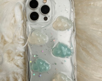 May include: Clear phone case with a white and blue cloud design and glitter accents.