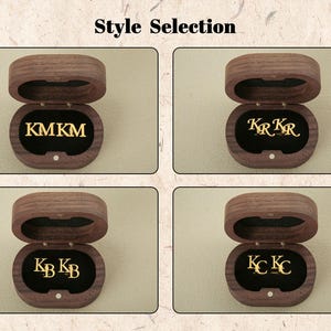 May include: Four wooden boxes with velvet interiors, each displaying a different style of personalized lettering. The boxes are open and show the lettering inside. The lettering styles are "KMKM", "KRKR", "KBKB", and "KCKC".