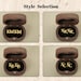 May include: Four wooden boxes with velvet interiors, each displaying a different style of personalized lettering. The boxes are open and show the lettering inside. The lettering styles are "KMKM", "KRKR", "KBKB", and "KCKC".