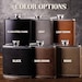 May include: Six different colour options for a hip flask. The flasks are made of metal and have a leather-like finish. The colours are black steel, grey, light brown, black, dark brown, and khaki.