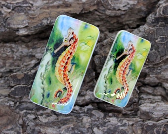 May include: Two rectangular ceramic tiles with a watercolor painting of a yellow and orange seahorse in a green and blue underwater scene.