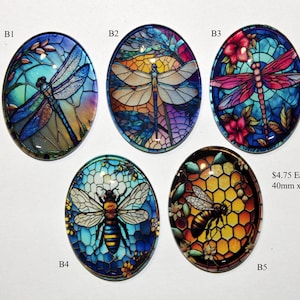 May include: Five oval-shaped glass cabochons with stained glass designs. The designs feature a dragonfly, a bee, and honeycomb. The cabochons are 40mm x 30mm and cost $4.75 each.