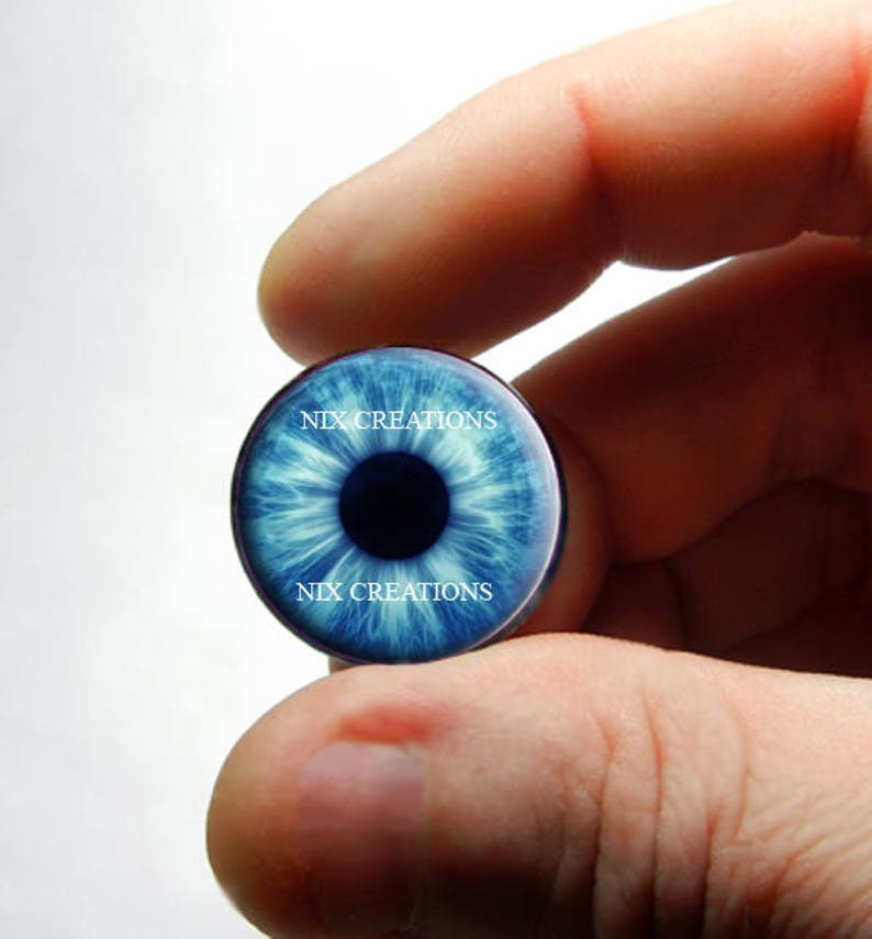 May include: A blue eye-shaped glass plug with the text "NIX CREATIONS" printed on it.