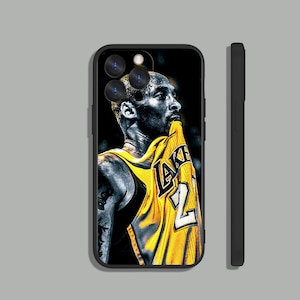 May include: Black and white illustration of a basketball player wearing a yellow and black Lakers jersey with the number 24 on the front. The player is looking up and has a determined expression on his face.