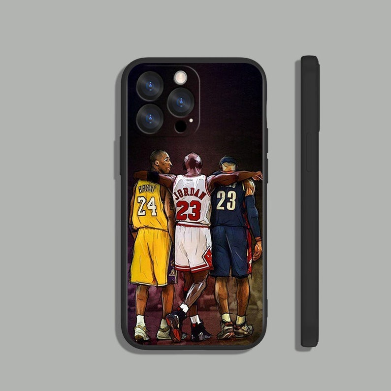 May include: Black iPhone case with a graphic of Michael Jordan, Kobe Bryant, and LeBron James wearing their basketball jerseys. The text "JORDAN 23", "BRYANT 24", and "JAMES 23" is visible on the jerseys.