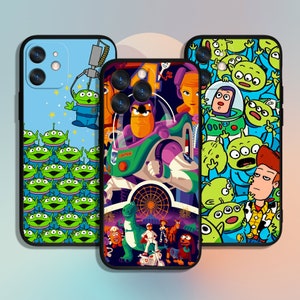 Peut inclure: Trois étuis de téléphone différents mettant en scène des personnages de la franchise Toy Story. Le premier étui est noir avec un motif d'extraterrestres vert, bleu et jaune. Le deuxième étui est noir avec une image colorée de Buzz l'Éclair et Woody. Le troisième étui est noir avec une image colorée de Buzz l'Éclair et Woody.