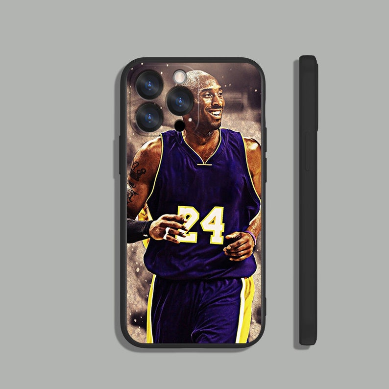May include: Black phone case with a photo of Kobe Bryant wearing a purple and gold basketball jersey with the number 24 on the front.