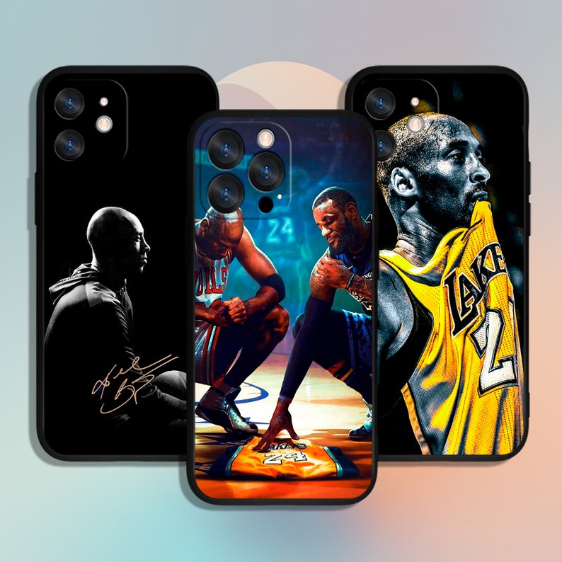 May include: Three different phone cases featuring basketball players. The first case is black with a silhouette of a basketball player in a black and white jersey. The second case features a basketball player in a red and white jersey and another player in a blue and white jersey. The third case features a basketball player in a yellow jersey with the word "LAKERS" on it.