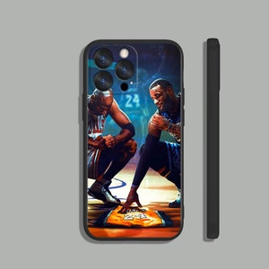 May include: A black phone case with a photo of Michael Jordan and LeBron James on a basketball court. The case features a close-up of the two basketball players with their jerseys on. The case also features the number "24" on the court.