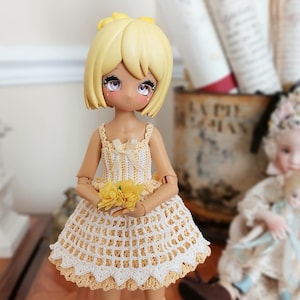 May include: A yellow-haired doll wearing a crocheted dress with a yellow flower pattern and holding a bouquet of yellow flowers.