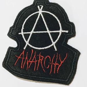May include: Black felt patch with a white anarchy symbol and the word "ANARCHY" embroidered in red.