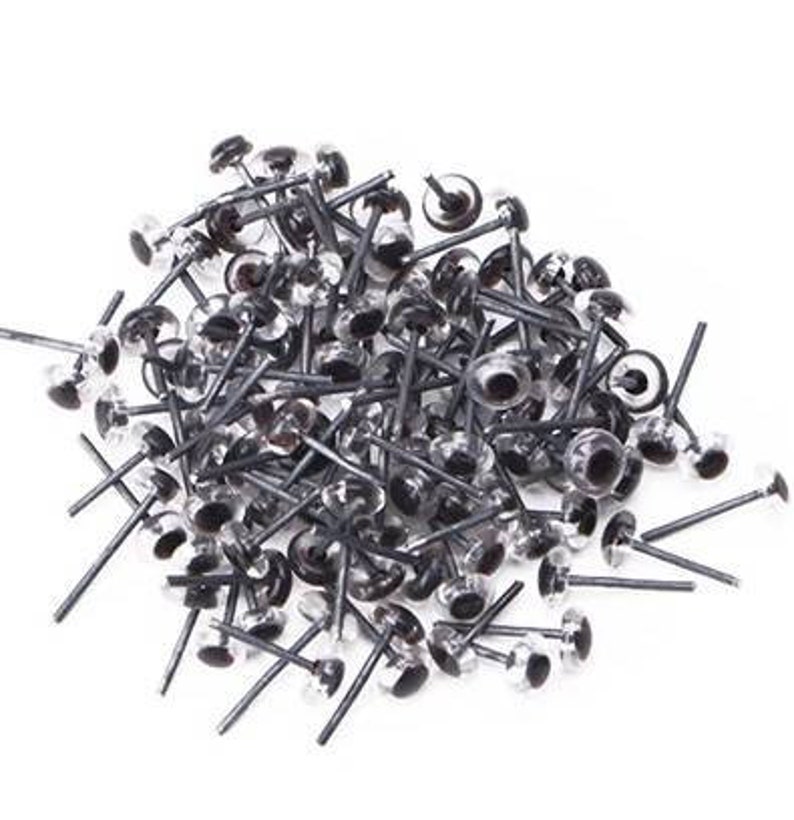 May include: A large pile of black and clear plastic safety eyes with metal posts. The eyes are used for crafts and sewing projects.