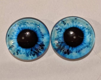 One pair of glass eyes bright blue with metal posts colour  various sizes