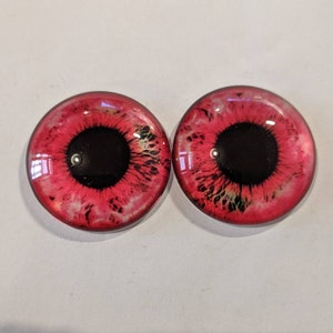 One pair of glass eyes red colour