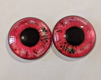 One pair of glass eyes red colour