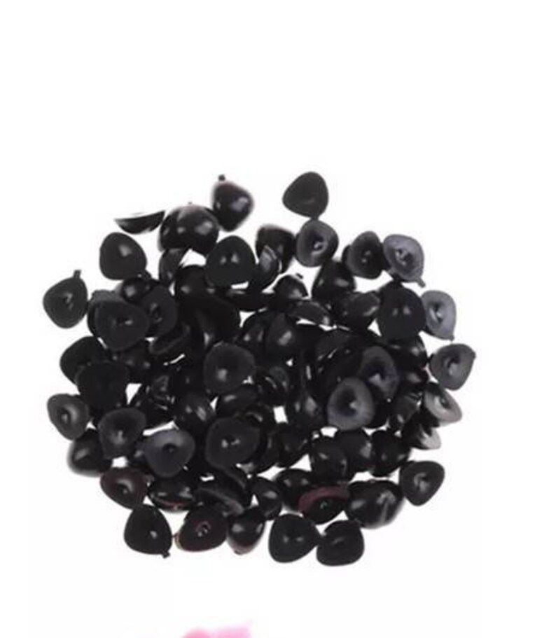 May include: A large pile of black plastic doll eyes. The eyes are all different sizes and shapes, but they are all black.